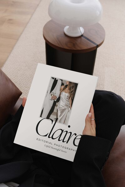 Luxury editorial brand guide held by a photographer, featuring romantic typography and a modern layout—ideal branding inspiration for wedding photographers.