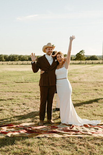 Bride and groom cheering after just getting married and about to walk down the isle