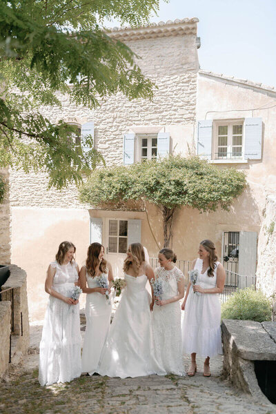 Romantic couple portraits at Bastide de Gordes with the bride in a silk fil-de-coupe wedding dress  and long wavy hair and the groom wearing a tan suit at sunset