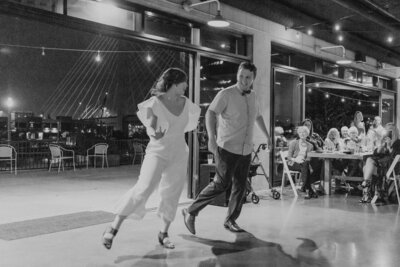 black and white image bride and groom dancing