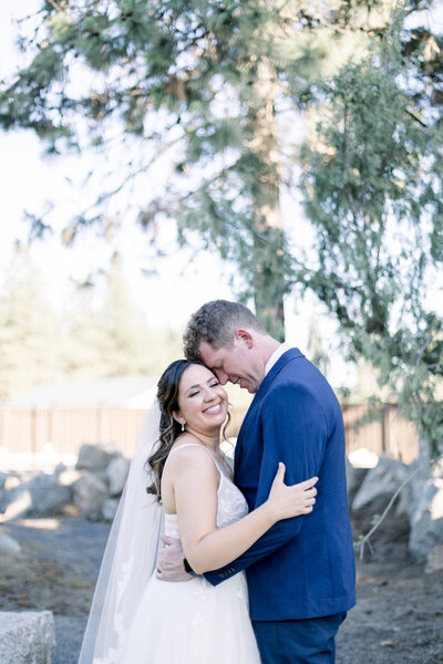 Bride and groom smiling and holding each other  taken by Spokane Wedding Photographer