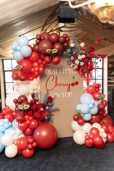 Cherry Themed baby shower backdrop with balloons and flowers in dallas texas.