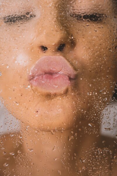 Woman in shower kissing the glass
