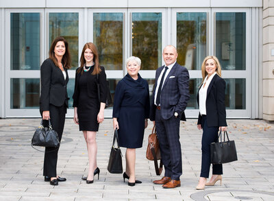 a group of corporate business people in suits standing on stairs for their group photo.  Capture indoors by Ottawa Commercial Photographer JEMMAN Photography