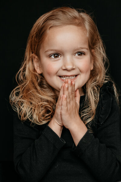 portret van een meisje met haar handjes bij elkaar