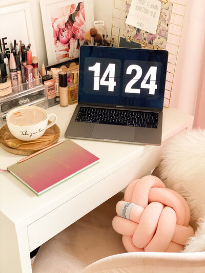 Hailey Ann Co Bookkeeper and somatic money coach. Pink Desk with tea, laptop and pink notebook