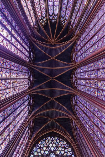 a view looking straight up in a cathedral of barrel arch ceilings and purple toned stained glass windows for amazon product videos for socialfizz