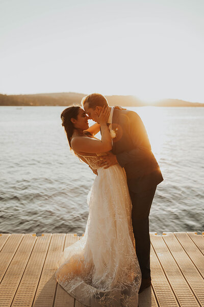 bride and groom kissing on dock