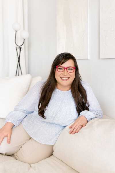 Photo of designer sitting on couch and looking at camera smiling