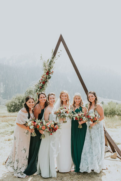 bride surrounded by bridesmaids holding flowers