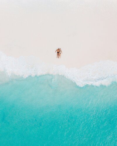 couple lying on beach from above