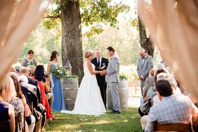 Bride and Groom holding hands and saying vows during their traditional wedding at Arrington Vineyards