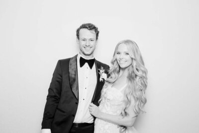 Bride and groom posing in black and white glam photo booth style