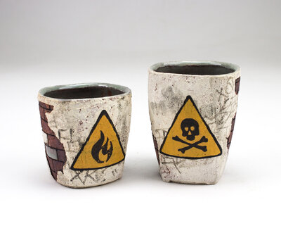 A ceramic cup that resembles plaster falling apart from red bricks with painted cacti and graffiti