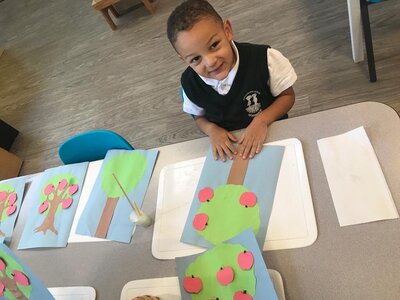 Student making a tree out of coloured paper in Montessori