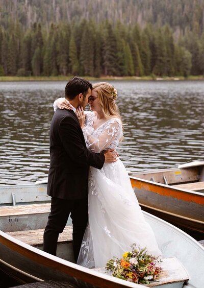 Newlyweds touching foreheads on a small rowboat