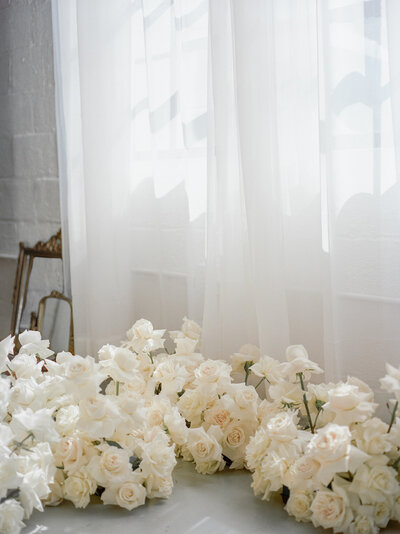 abundant blush white roses, light through petals and sheer curtains, antique vintage gold mirrors, florist film brand photo
