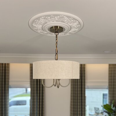 Light fixture hanging under a decorative medallion cover
