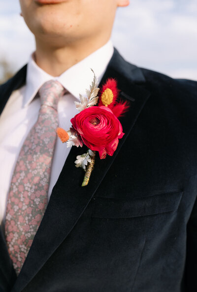 Close up of hot pink boutonniere on man's suit jacket