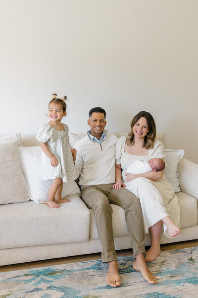 Newborn baby peacefully swaddled in a soft blanket, nestled in a basket surrounded by lush greenery in a garden. The serene setting highlights the baby's calm and gentle presence amidst nature