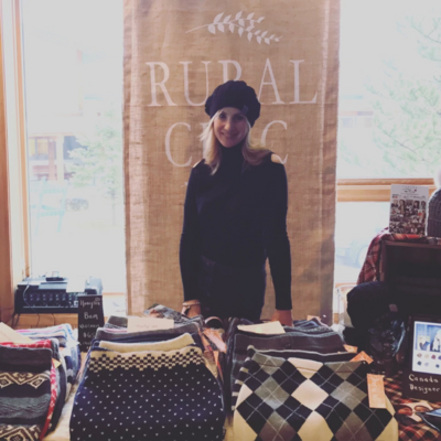 woman standing behind table of clothing