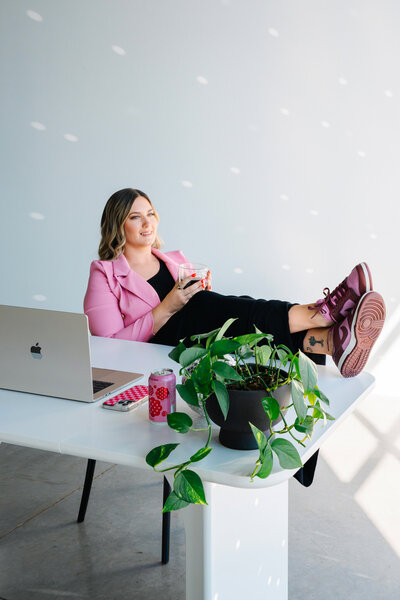 photographer working on computer with camera nearby