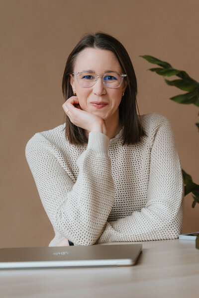 Portrait of local Kansas City brand owner wearing glasses and looking thoughtfully into camera.