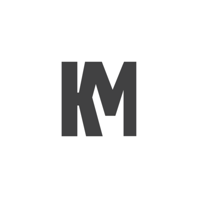 Kenzie Mosher sitting on a kitchen counter in a black blazer, holding a green smoothie — sharing her journey through burnout, gut issues, and hormones.