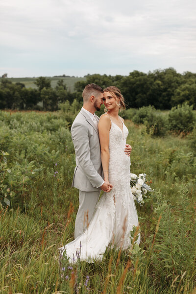 Bride and groom in a wild flower field in Iowa. 