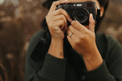 woman holding camera by her face
