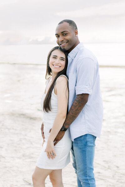 Man and woman smiling at camera in an engagement portrait taken by Tampa photographer, Tina Marie.