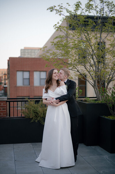 Candid rooftop wedding portrait of bride and groom in Chicago, captured by documentary-style wedding photographer Abe Fernandez on digital and 35mm film