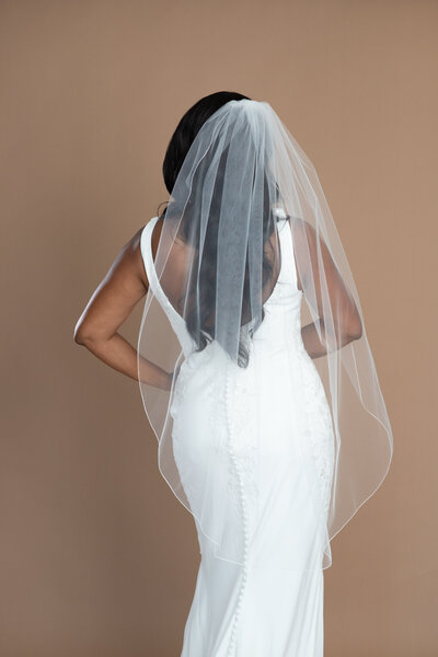 Bride wearing a fingertip length veil with small serged edge