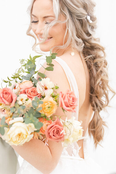 bright light and airy wedding photo of bride  with bouquet