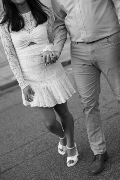 Engaged couple holds hands in the middle of the street