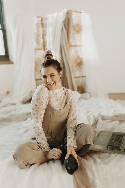 woman smiling sitting on bed