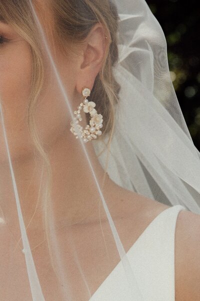 Close-up van oorbellen en sluier bruid door trouwfotograaf in Nederland Linda Photography