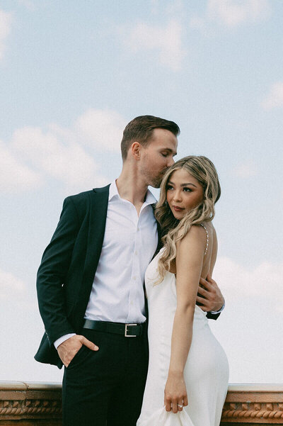 groom kissing bride's head by wedding photographer in south florida