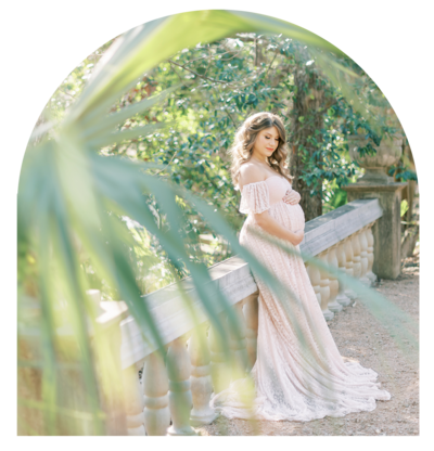 Woman in white robe closing eyes in a maternity portrait.