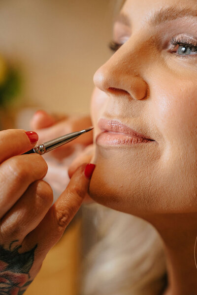 Libby applies makeup to a client representing makeup lessons offered by Looks with Libby.
