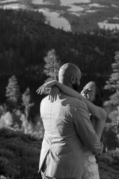 A newlywed couple with their arms around each other smiling