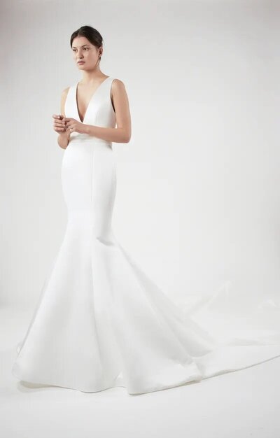 Bride in a sleek V-neck fitted gown with mermaid silhouette.