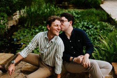gay couple sitting down kissing each other