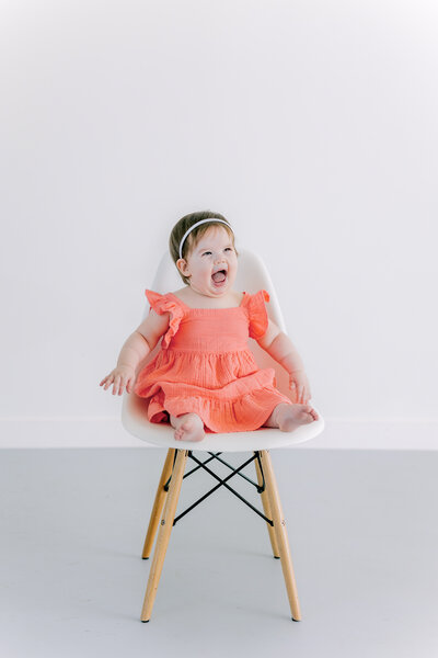 A little girl smiles into a Richmond family photographer's camera during her family photoshoot.