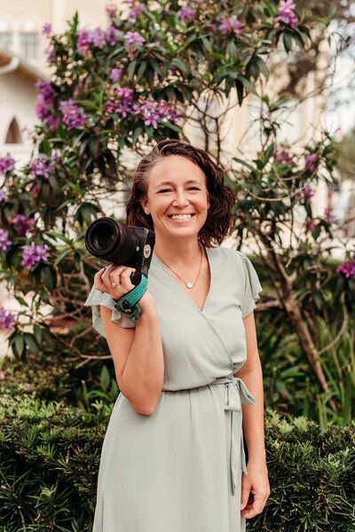 Memphis photographer, Jen Howell, holds her baby in front of a flowering tree.
