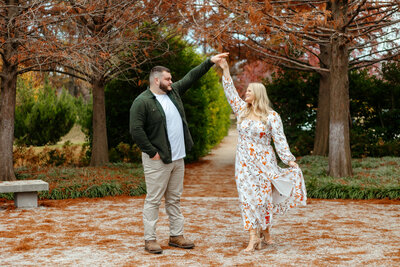 Romantic 'Spin of Love' engagement moment captured by Style & Grace Photography at Forest Park, St. Louis, MO, showcasing the couple’s joyful connection and love.