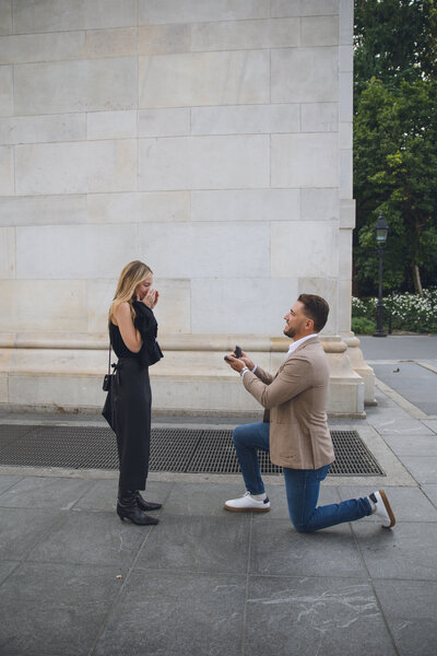 Groom proposing to bride at a monument in Philadelphia during engagement session