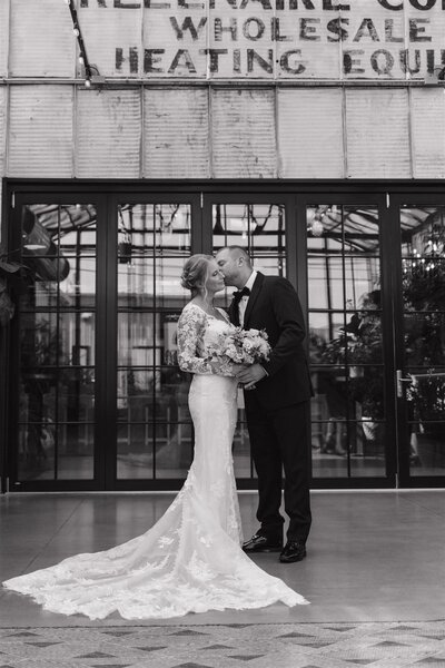 photo of a bride and groom while standing in a solarium or greenhouse taken by Wedding photographer near me