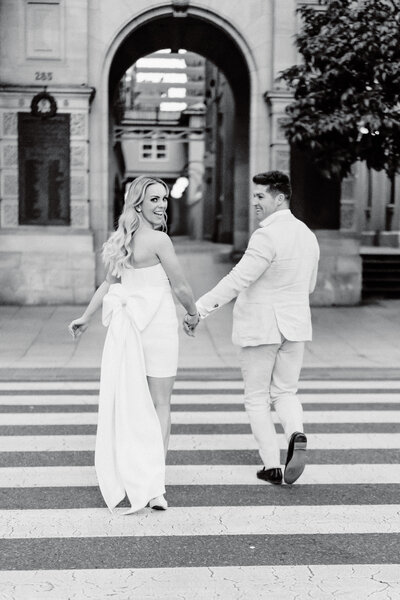 Bride and Groom run across a zebra crossing in the middle of Brisbane city - Wedding photographer in Brisbane