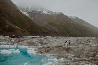 Couple walks along the glacial ice in Alaska on their elopement day.